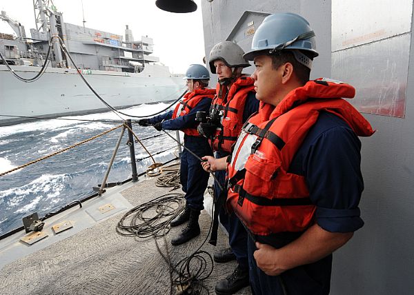 Sailors aboard guided-missile cruiser USS Vicksburg (CG 69) man a receiving station during a replenishment-at-sea with Military Sealift Command fast combat support ship USNS Supply (T-AOE 6).