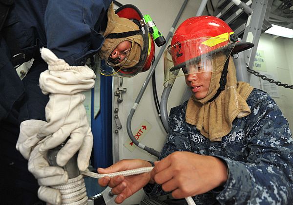 Sailors prepare an inline educator for use on a simulated flooding casualty during a general quarters drill.